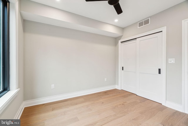 unfurnished bedroom with baseboards, a closet, visible vents, and light wood-style floors