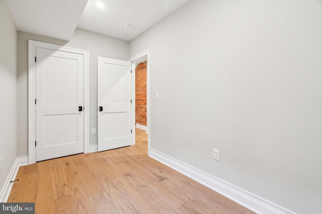 unfurnished bedroom with light wood-style flooring and baseboards