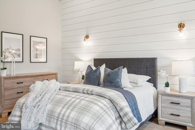 bedroom featuring wood walls and wood finished floors