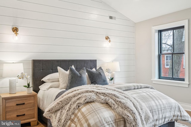 bedroom with lofted ceiling and visible vents