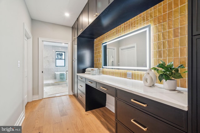 full bath featuring tasteful backsplash, vanity, baseboards, and wood finished floors