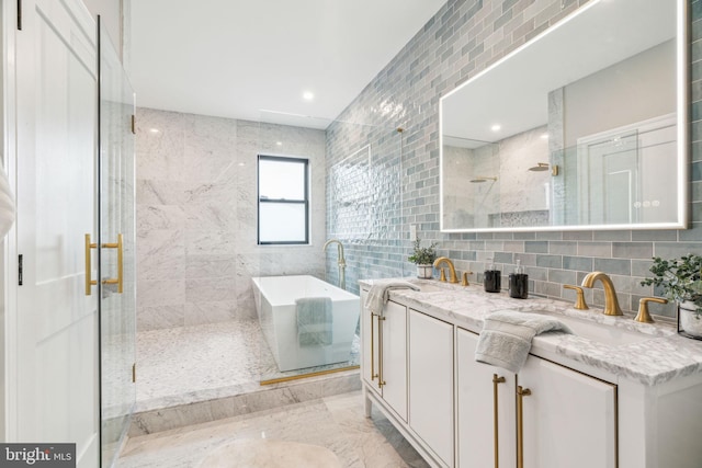 full bathroom featuring a stall shower, a soaking tub, a sink, and tile walls