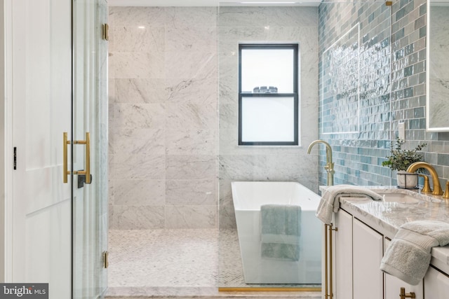 full bathroom featuring a soaking tub, a shower stall, and vanity