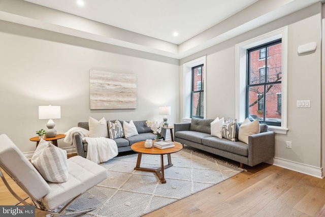 living area with plenty of natural light, light wood-style flooring, and baseboards