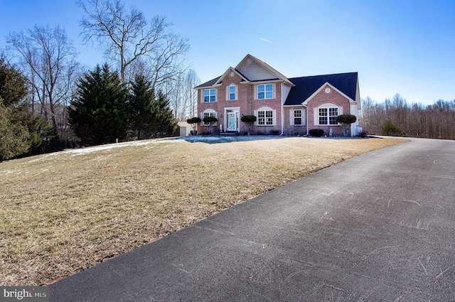 traditional-style home with brick siding and a front yard