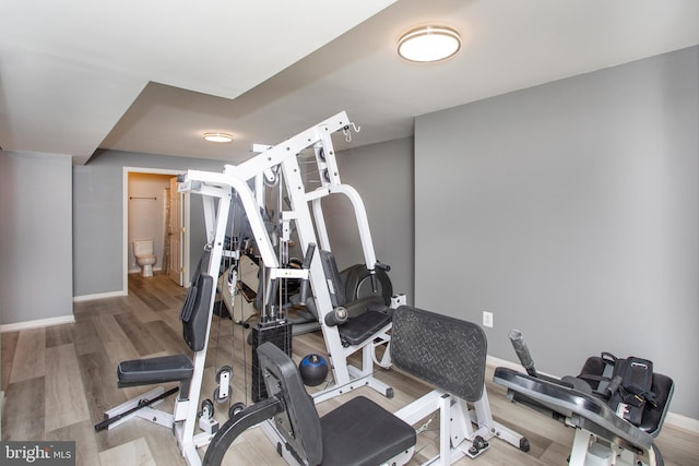 exercise area featuring baseboards and wood finished floors