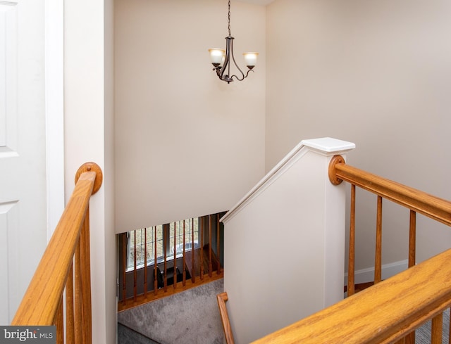 stairway with a notable chandelier