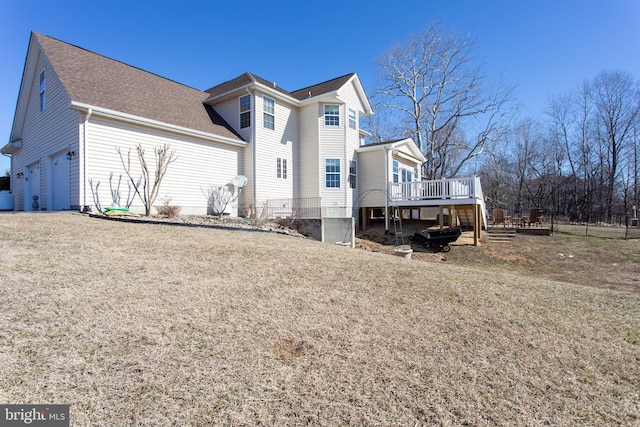 view of home's exterior featuring a deck, a shingled roof, and a lawn