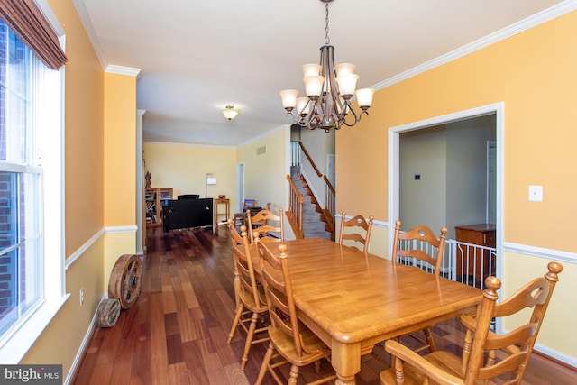 dining area featuring a notable chandelier, wood finished floors, baseboards, ornamental molding, and stairway