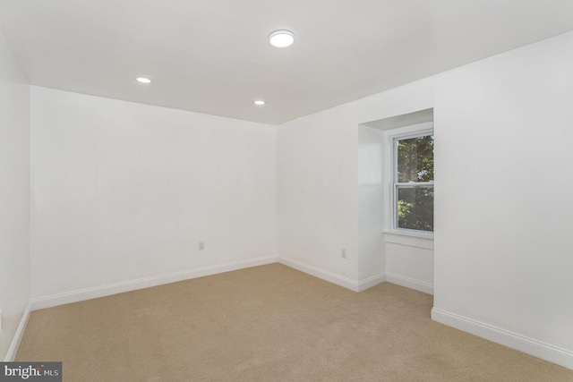 empty room with light carpet, recessed lighting, and baseboards