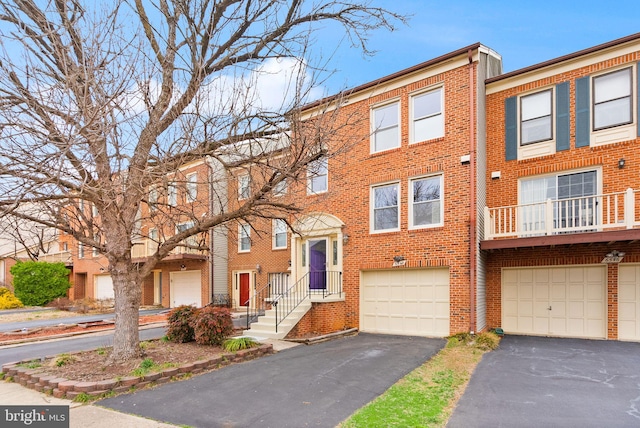 townhome / multi-family property featuring brick siding, driveway, and a garage