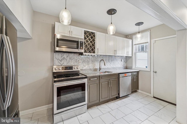 kitchen featuring stainless steel appliances, tasteful backsplash, a sink, and light stone counters