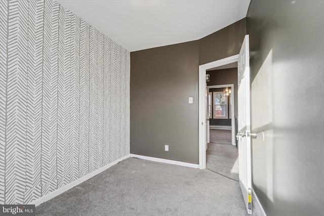 interior space featuring an accent wall, a baseboard radiator, and baseboards