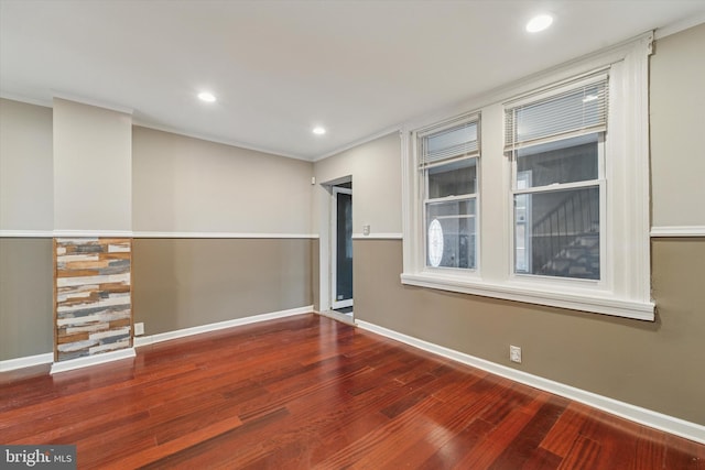 empty room with ornamental molding, recessed lighting, baseboards, and wood finished floors