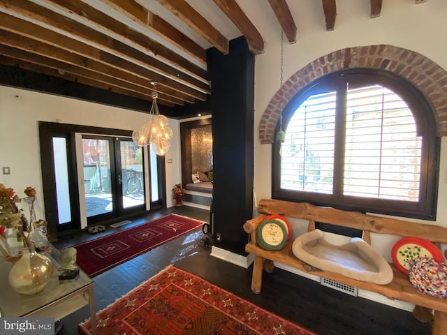 foyer entrance with a chandelier, beam ceiling, visible vents, and french doors