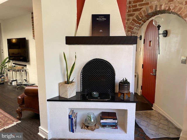 details with arched walkways, wood finished floors, and baseboards