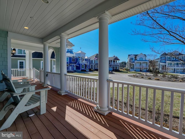 wooden terrace featuring a residential view and covered porch