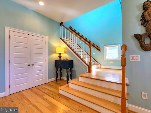 stairway with wood finished floors and baseboards