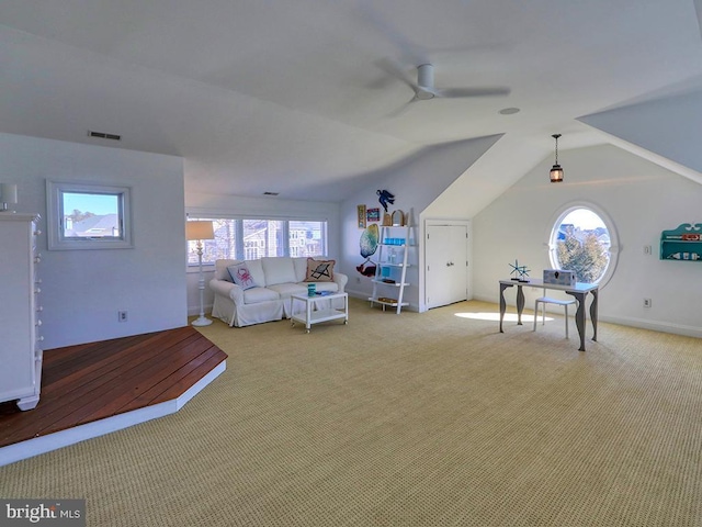 unfurnished living room featuring a wealth of natural light, carpet, visible vents, and lofted ceiling