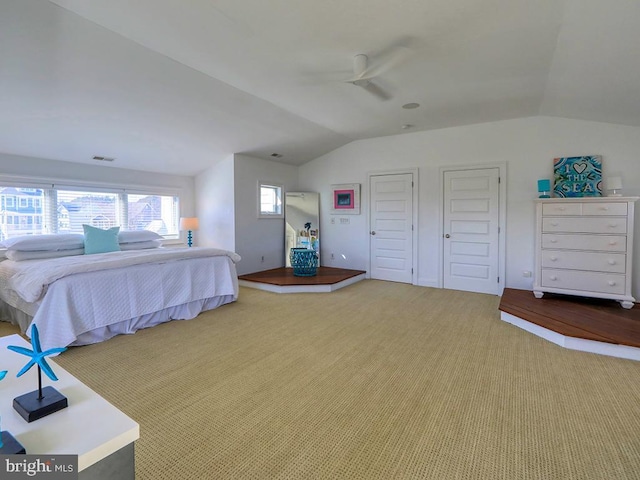 carpeted bedroom with a ceiling fan, visible vents, and vaulted ceiling