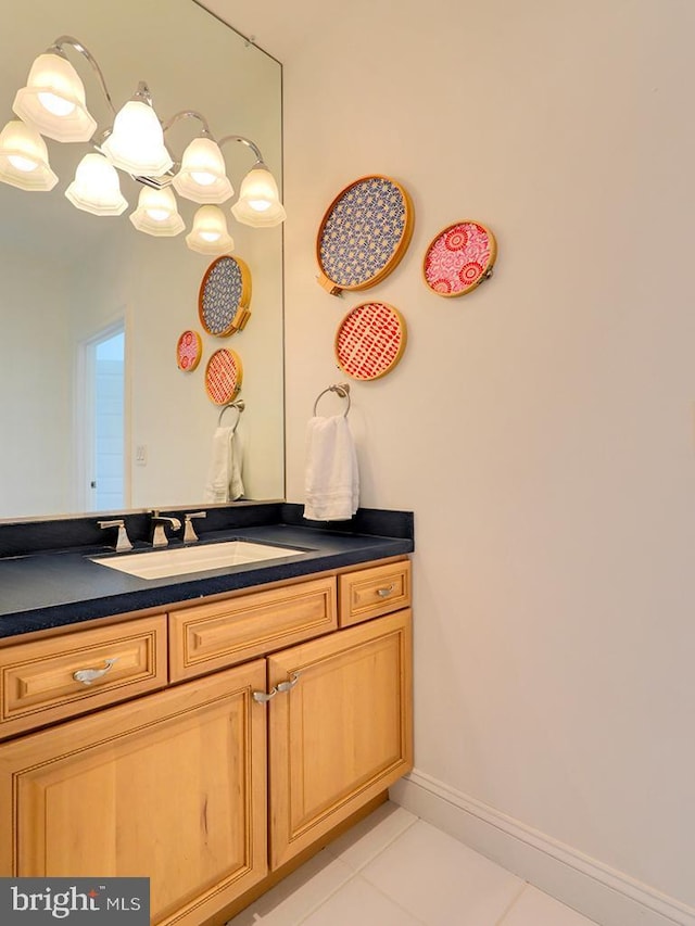 bathroom featuring an inviting chandelier, tile patterned flooring, vanity, and baseboards