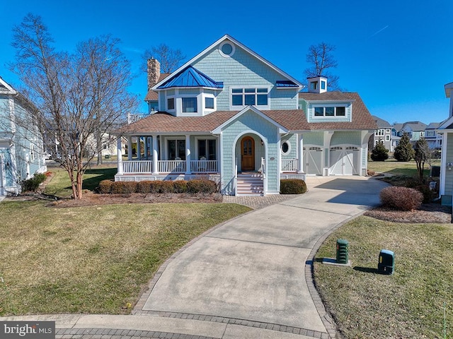 view of front facade with covered porch, concrete driveway, a front yard, and a garage