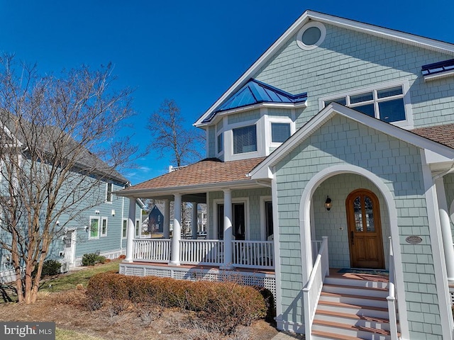 view of front of home featuring covered porch and roof with shingles