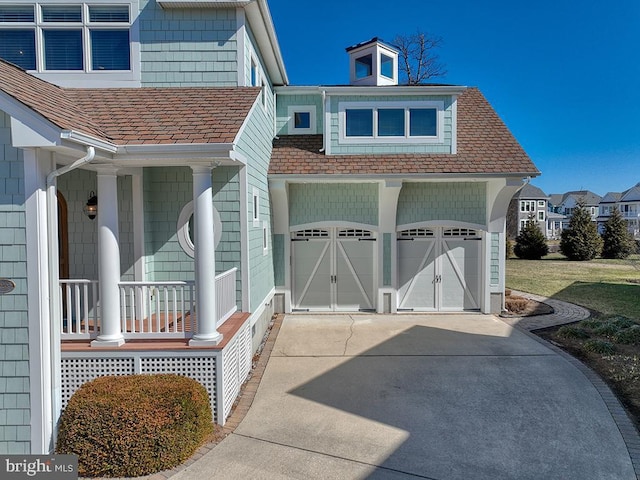 view of side of property with concrete driveway and a porch