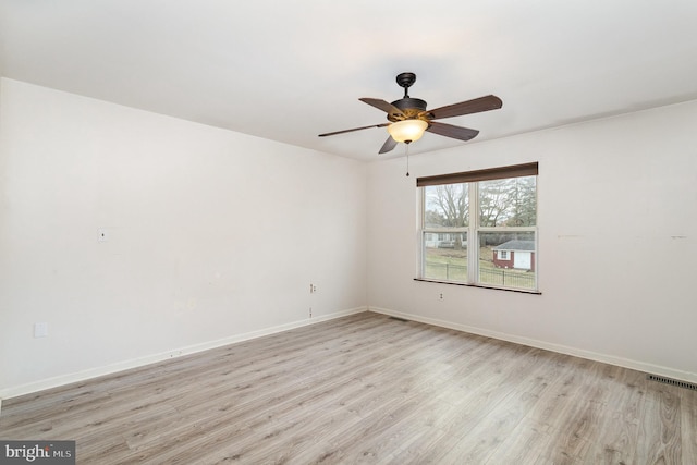 unfurnished room with ceiling fan, light wood-type flooring, visible vents, and baseboards