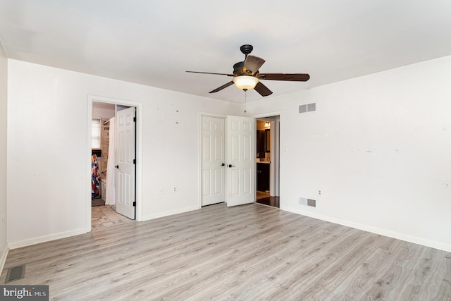 empty room with light wood-style flooring, visible vents, and baseboards