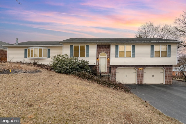 view of front of property with driveway, an attached garage, and brick siding