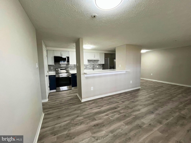 interior space with a textured ceiling, dark wood-style flooring, and baseboards