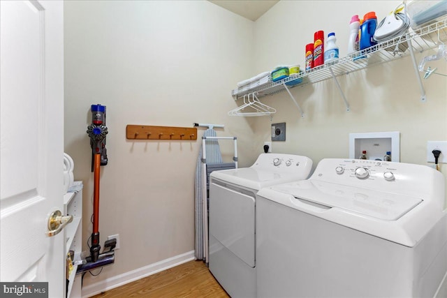 laundry room featuring light wood-style floors, washing machine and dryer, laundry area, and baseboards