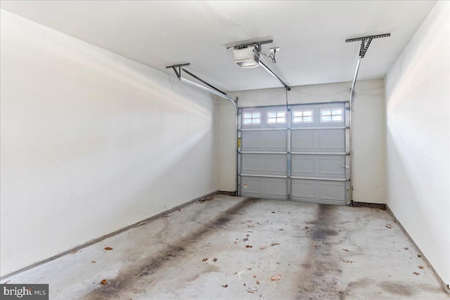 garage with baseboards and a garage door opener