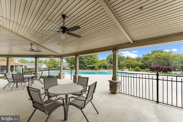 view of patio / terrace with fence, a fenced in pool, and a ceiling fan