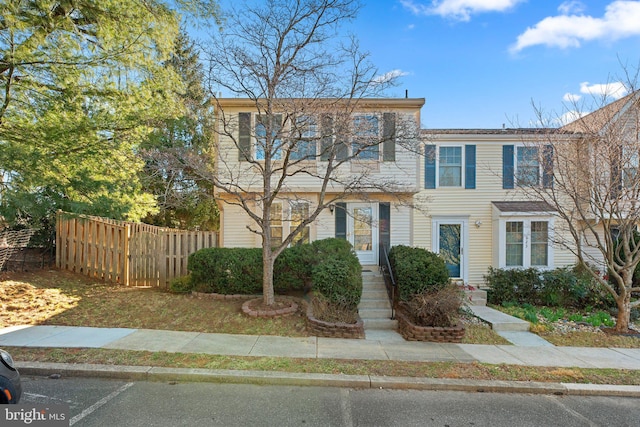 view of front of house featuring uncovered parking and fence