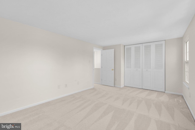 unfurnished bedroom with a closet, visible vents, baseboards, and carpet floors