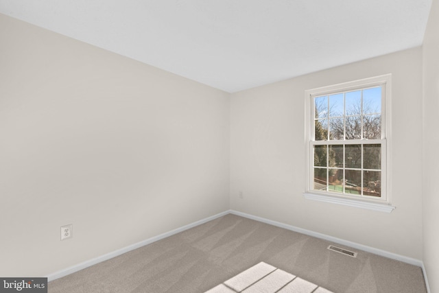 carpeted empty room featuring visible vents and baseboards