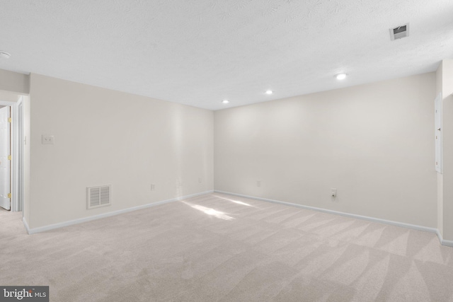 unfurnished room featuring visible vents, light colored carpet, and baseboards