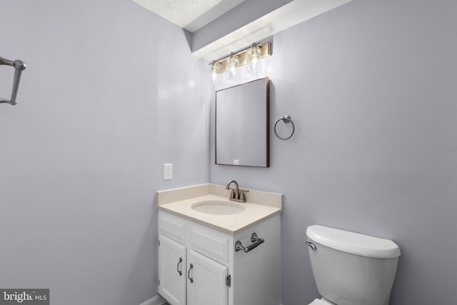 bathroom featuring vanity, toilet, and a textured ceiling