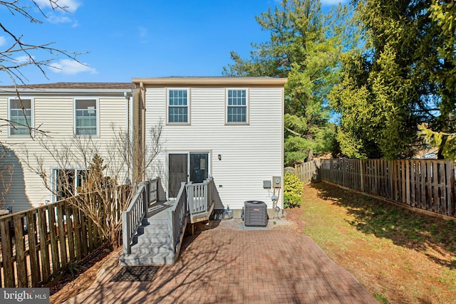 back of property with a patio area, a deck, cooling unit, and a fenced backyard