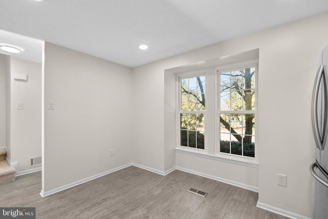 unfurnished living room with visible vents, recessed lighting, light wood-type flooring, and baseboards