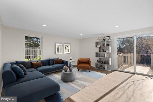 living area with recessed lighting, a healthy amount of sunlight, and wood finished floors