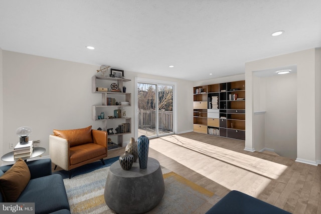 living area with recessed lighting, wood finished floors, and baseboards