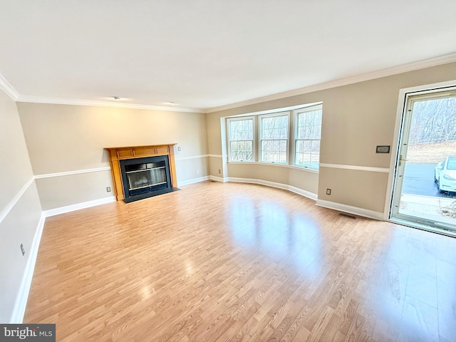 unfurnished living room featuring baseboards, crown molding, a fireplace with flush hearth, and light wood-style floors