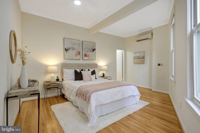 bedroom with baseboards, wood finished floors, crown molding, an AC wall unit, and beam ceiling