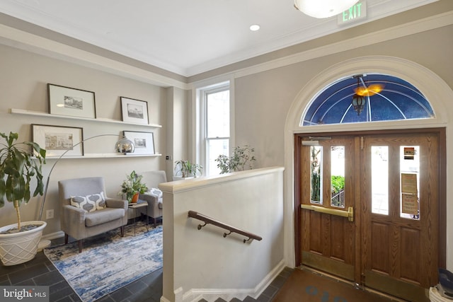 foyer featuring crown molding, dark tile patterned flooring, and plenty of natural light