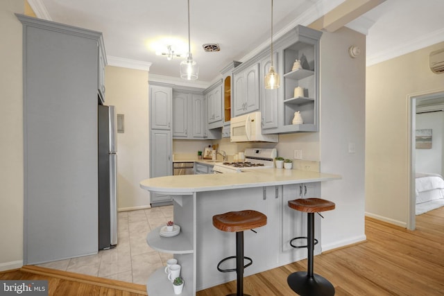 kitchen with range, open shelves, a peninsula, and white microwave