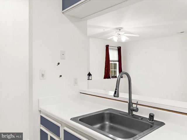 kitchen featuring a ceiling fan, light countertops, and a sink