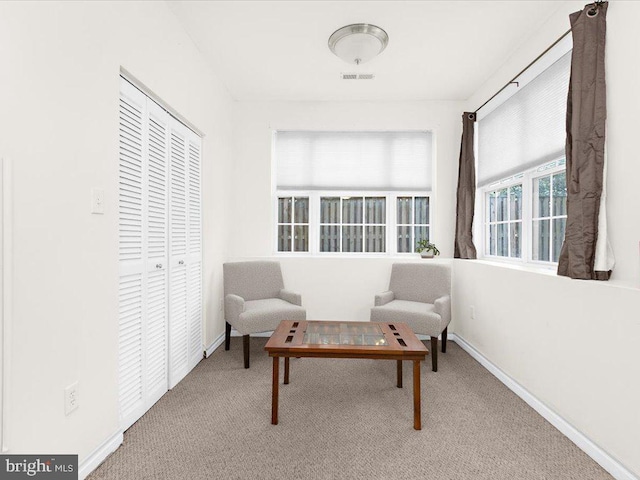 living area featuring carpet flooring, visible vents, and baseboards